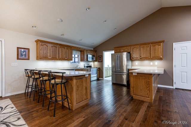 kitchen featuring dark hardwood / wood-style floors, sink, a breakfast bar area, and appliances with stainless steel finishes