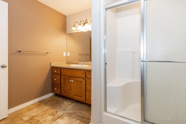 bathroom with a shower with door and vanity