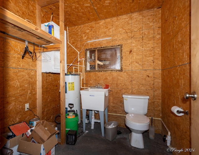 bathroom with electric water heater, toilet, and sink