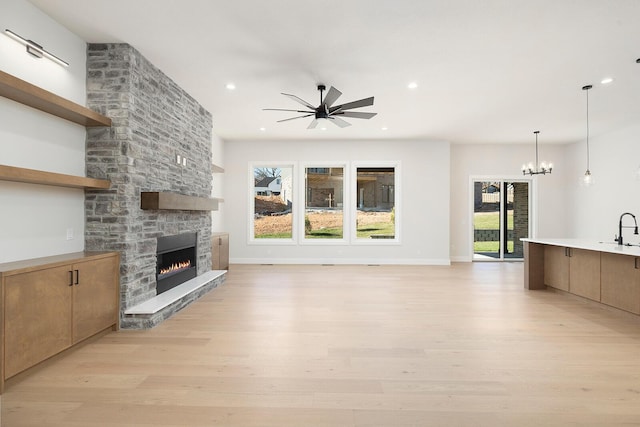 unfurnished living room featuring plenty of natural light, a fireplace, and light hardwood / wood-style flooring