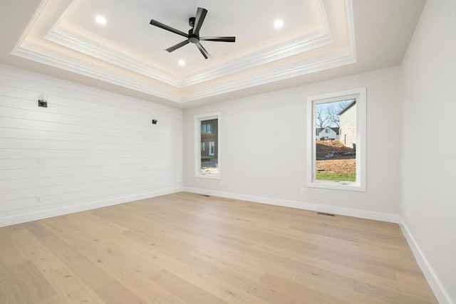 unfurnished room with light hardwood / wood-style floors, a raised ceiling, ceiling fan, and crown molding