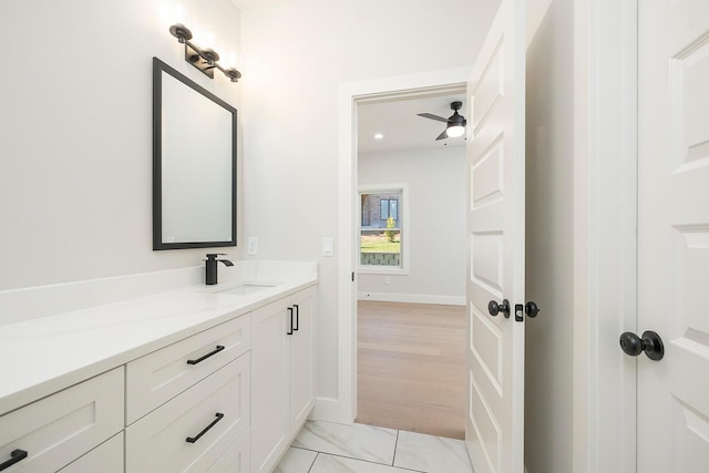 bathroom with hardwood / wood-style floors, ceiling fan, and vanity