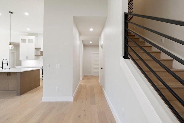 hallway featuring sink and light hardwood / wood-style flooring