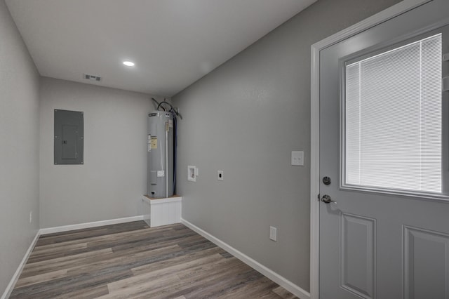 laundry room with electric water heater, electric panel, hookup for a washing machine, hardwood / wood-style flooring, and hookup for an electric dryer