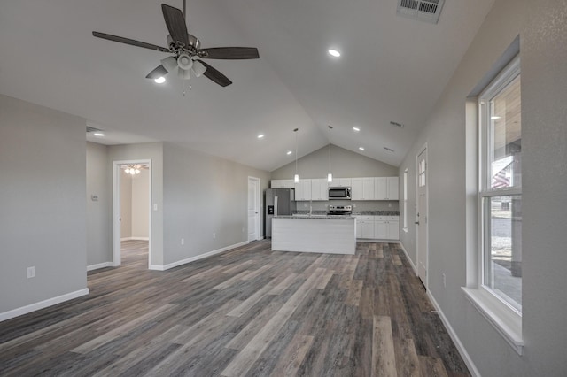 kitchen with a center island, wood-type flooring, white cabinetry, hanging light fixtures, and appliances with stainless steel finishes