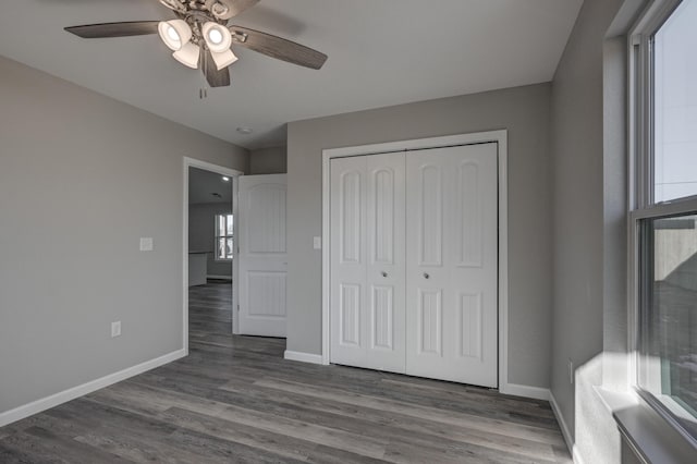 unfurnished bedroom with ceiling fan, a closet, and wood-type flooring