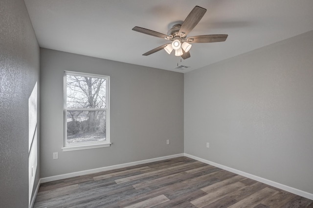 empty room with ceiling fan and dark wood-type flooring