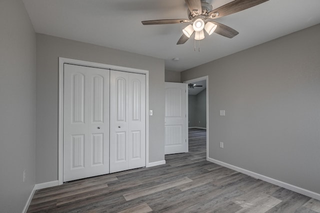 unfurnished bedroom featuring ceiling fan, a closet, and hardwood / wood-style flooring