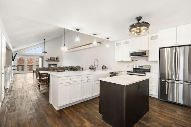 kitchen with white cabinets, a center island, appliances with stainless steel finishes, and pendant lighting