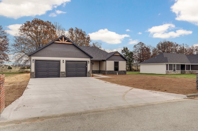 view of front facade featuring stone siding, driveway, an attached garage, and a front lawn