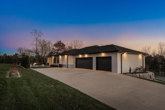 property exterior at dusk featuring a garage and a yard