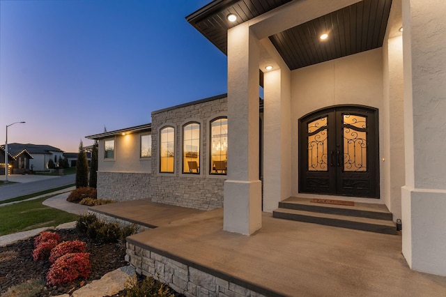 exterior entry at dusk featuring french doors