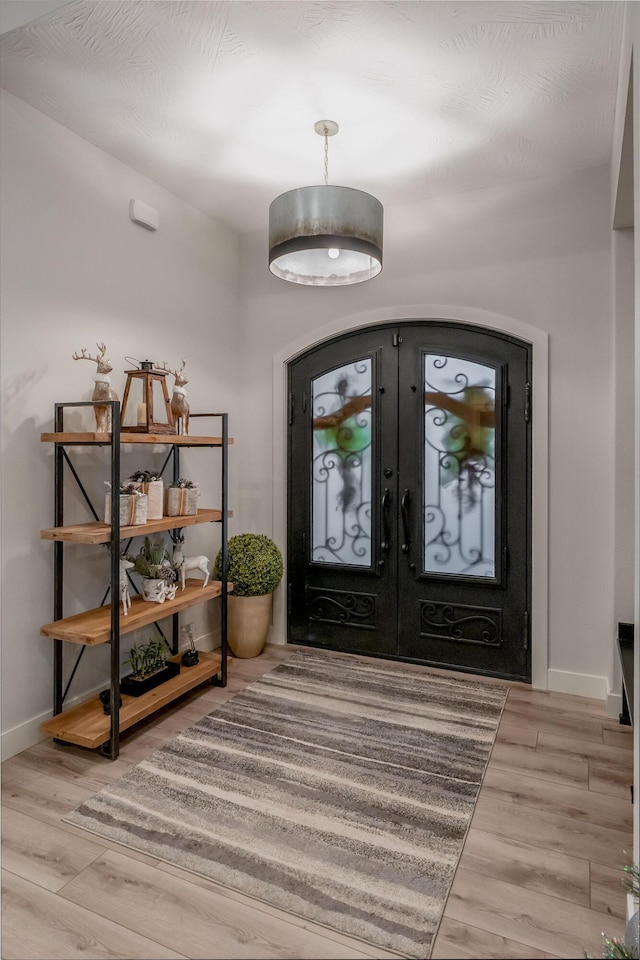 foyer with light wood-type flooring and french doors