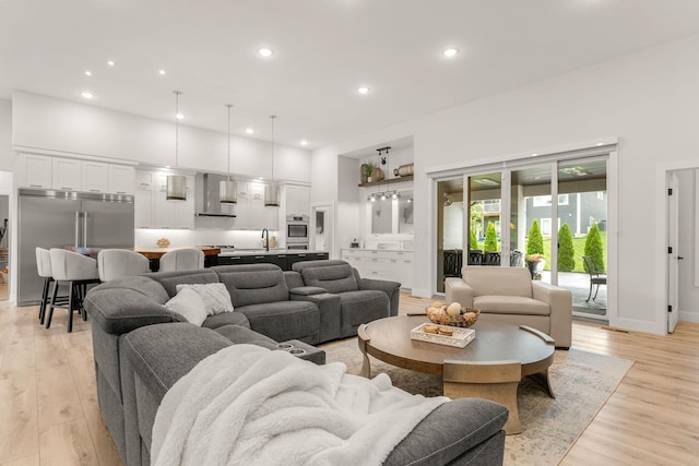 living room featuring sink and light hardwood / wood-style flooring