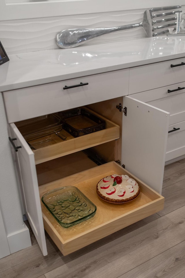 details with white cabinets and light hardwood / wood-style floors