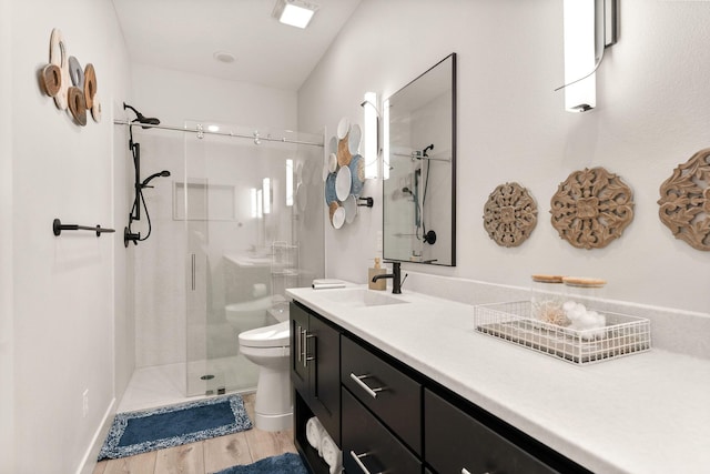 bathroom featuring a shower with shower door, toilet, wood-type flooring, and vanity