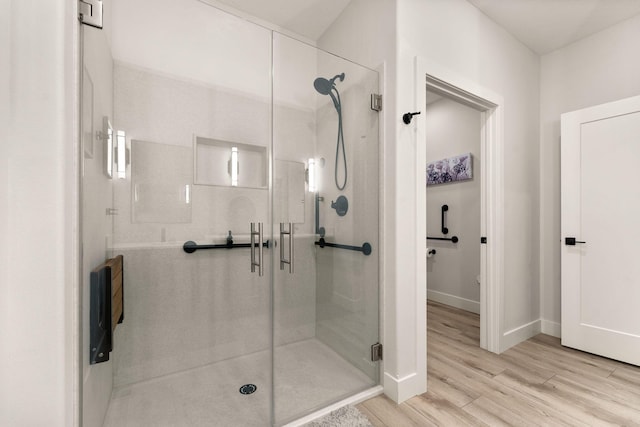 bathroom with hardwood / wood-style flooring and walk in shower