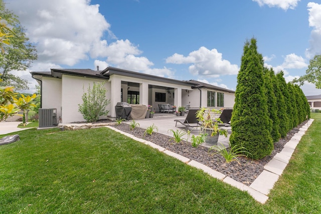 rear view of house with a yard, a patio, and cooling unit