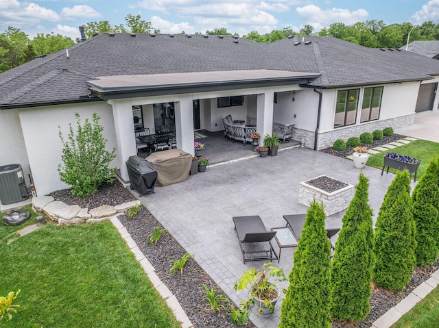 back of property with a lawn, a patio area, and central AC