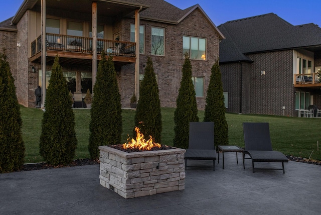 view of patio with a balcony and a fire pit