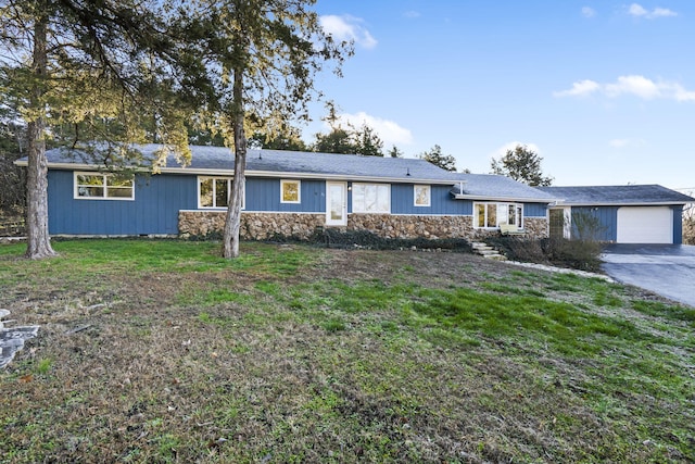 ranch-style home featuring a garage and a front lawn