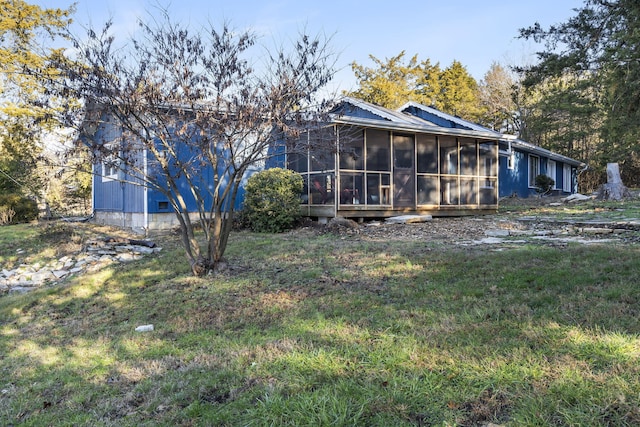 back of house with a sunroom and a lawn