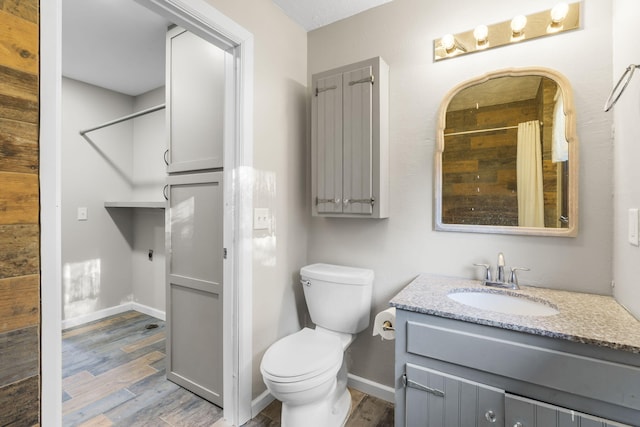 bathroom with toilet, vanity, curtained shower, and hardwood / wood-style flooring