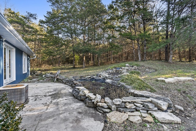 view of yard with central air condition unit and a patio