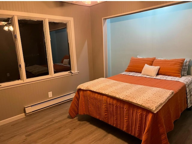 bedroom featuring a baseboard radiator and hardwood / wood-style floors