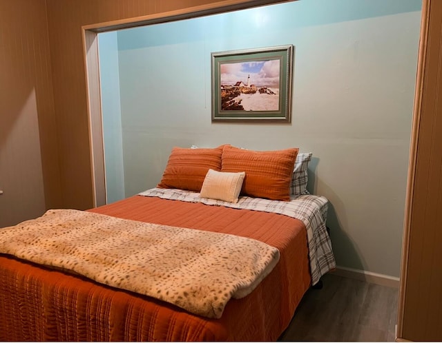 bedroom with baseboards and wood finished floors