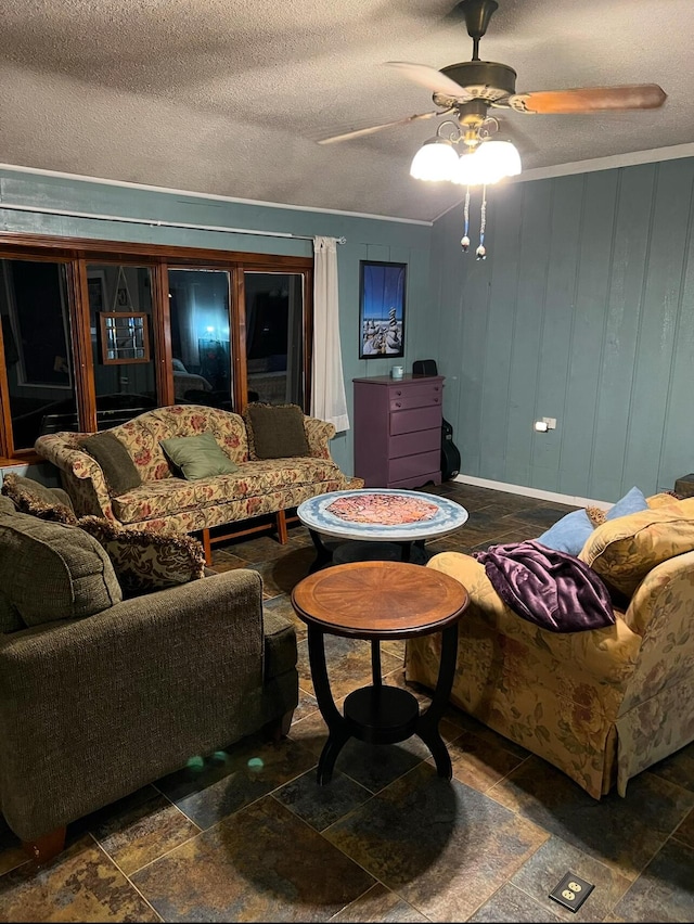 living room with stone finish flooring, ceiling fan, and a textured ceiling