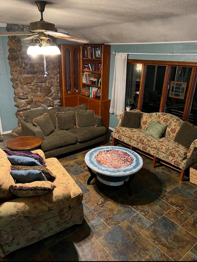 living room featuring ceiling fan and a textured ceiling