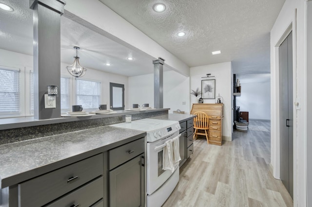 kitchen featuring gray cabinetry, a textured ceiling, light hardwood / wood-style flooring, a chandelier, and white electric range