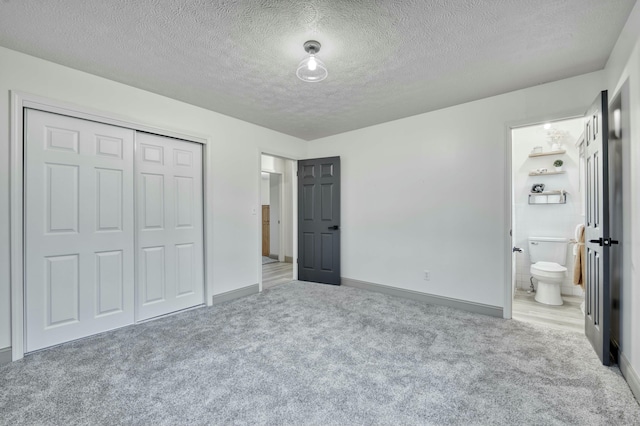 unfurnished bedroom with a closet, carpet floors, and a textured ceiling