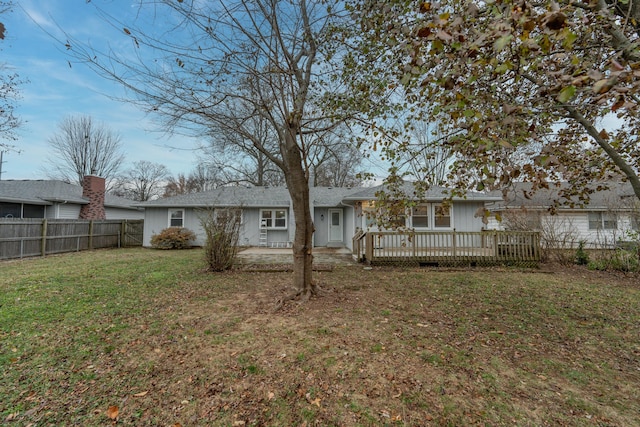 back of property with a deck and a lawn