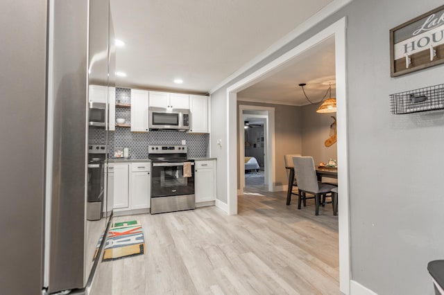 kitchen featuring backsplash, white cabinets, hanging light fixtures, light hardwood / wood-style flooring, and appliances with stainless steel finishes