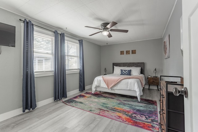 bedroom featuring ceiling fan, light hardwood / wood-style floors, and ornamental molding