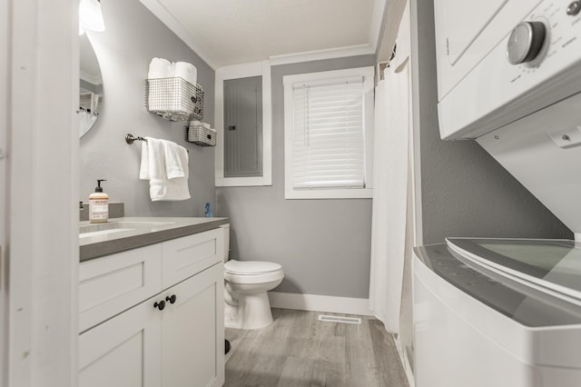 bathroom featuring vanity, crown molding, wood-type flooring, electric panel, and toilet