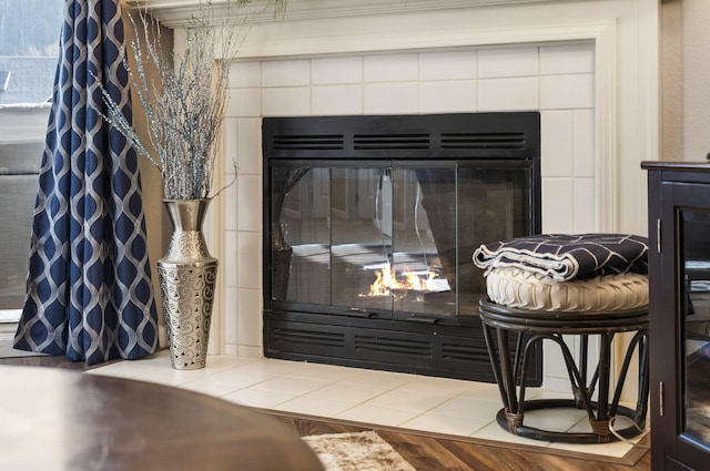 details featuring a tile fireplace and hardwood / wood-style floors