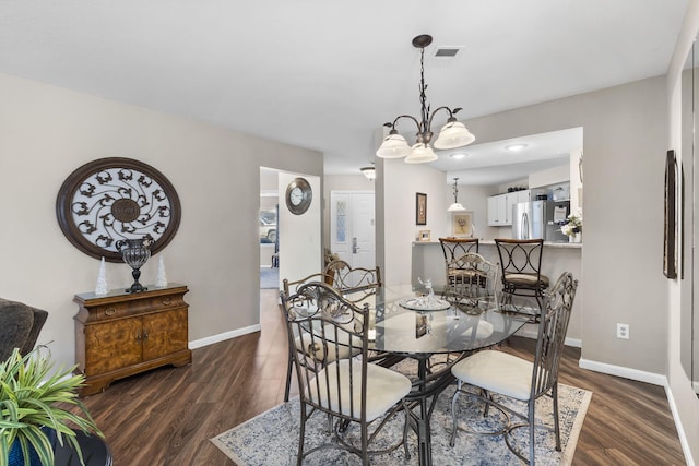 dining area featuring dark hardwood / wood-style floors and an inviting chandelier