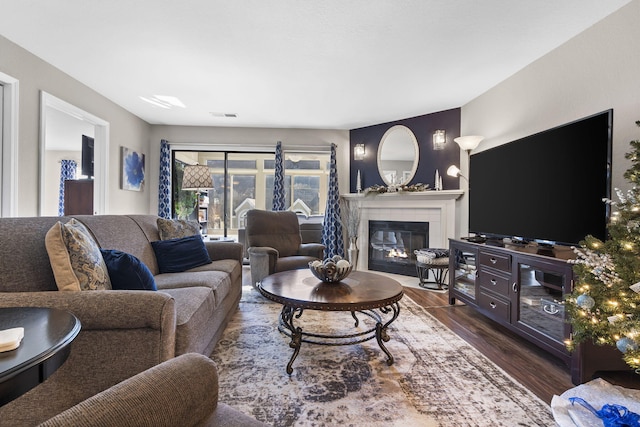 living room with dark hardwood / wood-style flooring and a tiled fireplace