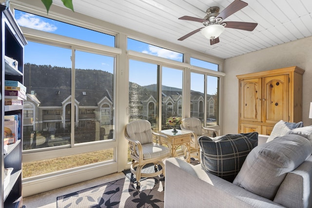 sunroom / solarium featuring plenty of natural light, ceiling fan, and a mountain view