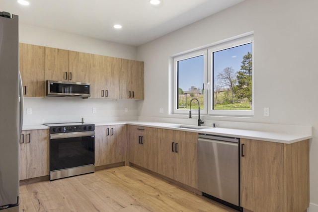 252 Hickory Hills Blvd, Springfield, MO 65802 - kitchen featuring stainless steel appliances, light countertops, a sink, and light wood-style floors