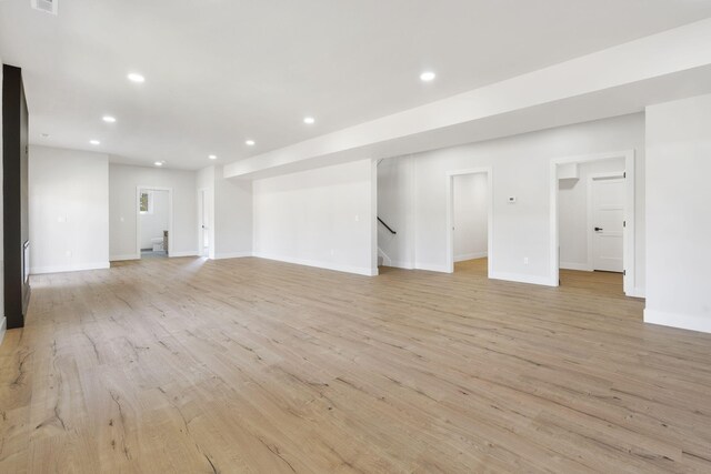 252 Hickory Hills Blvd, Springfield, MO 65802 - unfurnished living room with light wood finished floors, baseboards, recessed lighting, and stairway