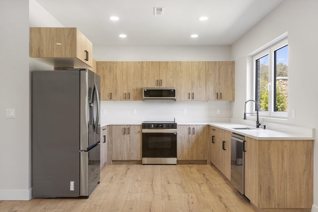 252 Hickory Hills Blvd, Springfield, MO 65802 - kitchen with a sink, light wood-style floors, stainless steel appliances, light countertops, and recessed lighting