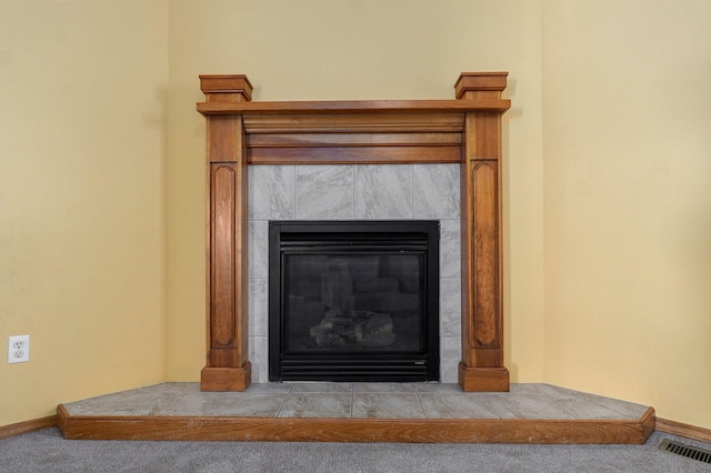 room details featuring carpet flooring and a tiled fireplace