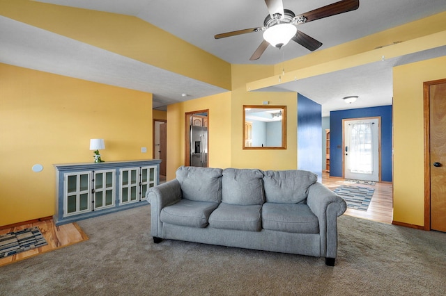 carpeted living room featuring ceiling fan and vaulted ceiling