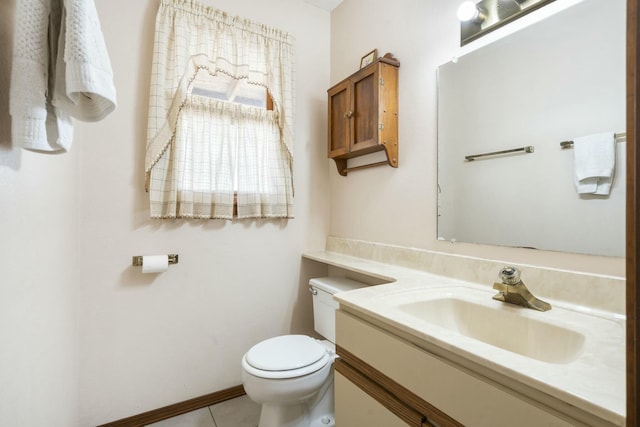 bathroom with tile patterned floors, toilet, vanity, and baseboards