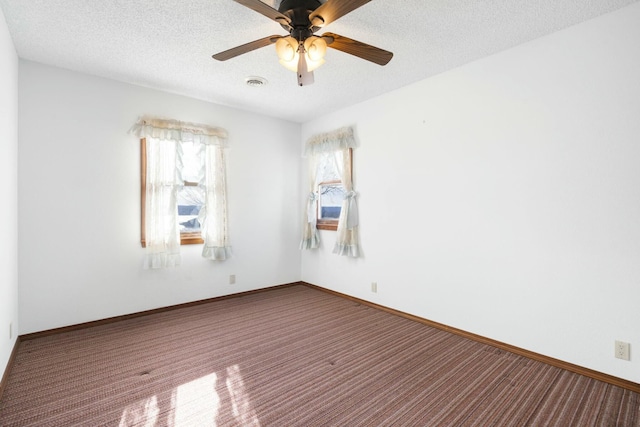 spare room featuring visible vents, baseboards, a textured ceiling, and carpet flooring