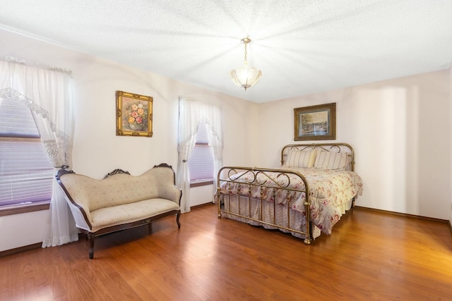 bedroom featuring baseboards and wood finished floors